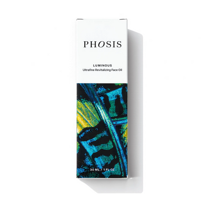 PHOSIS Luminous Ultimate Revitalizing Face Oil in a tall rectangular white box with black text and an abstract blue, green, and yellow painted design on the lower half, shown on a white background with a soft shadow.