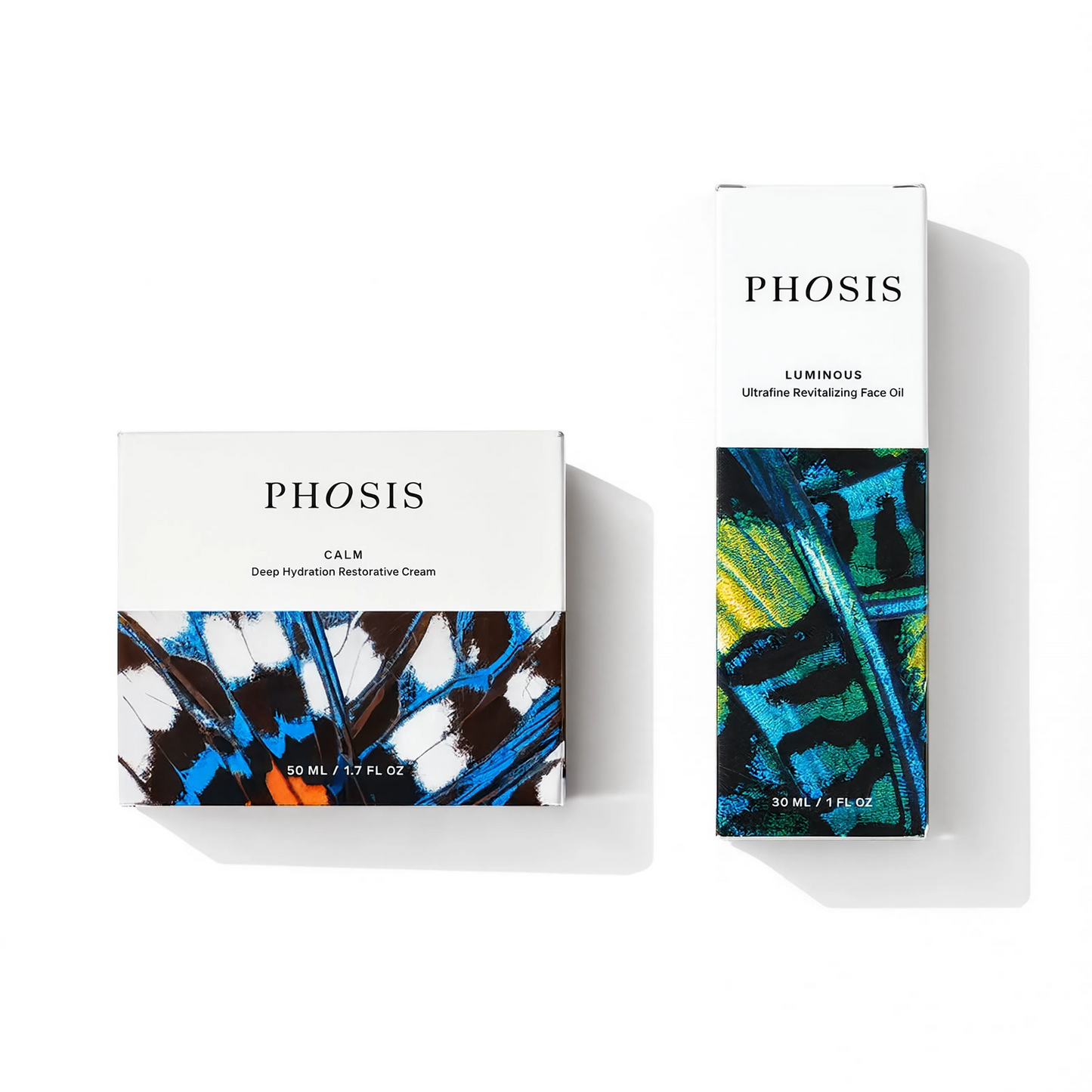 Two boxes of skincare products with white on the top part of the boxes and colored butterfly wing patterns on the bottom of the boxes. One box is labeled PHOSIS Calm Deep Hydration Restorative Cream and the other box is labeled PHOSIS Luminous Ultrafine Revitalizing Face Oil